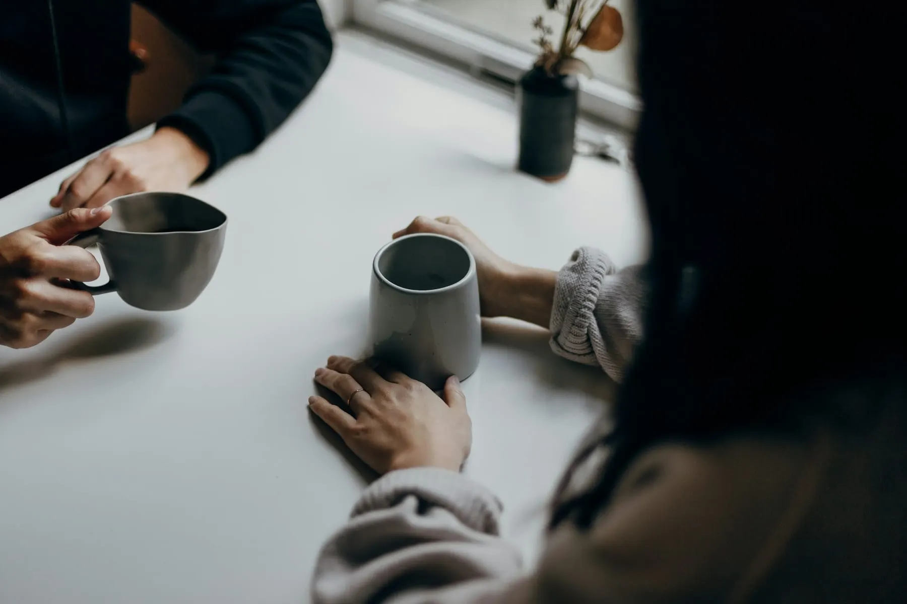 To personer i samtale over et bord med kaffe